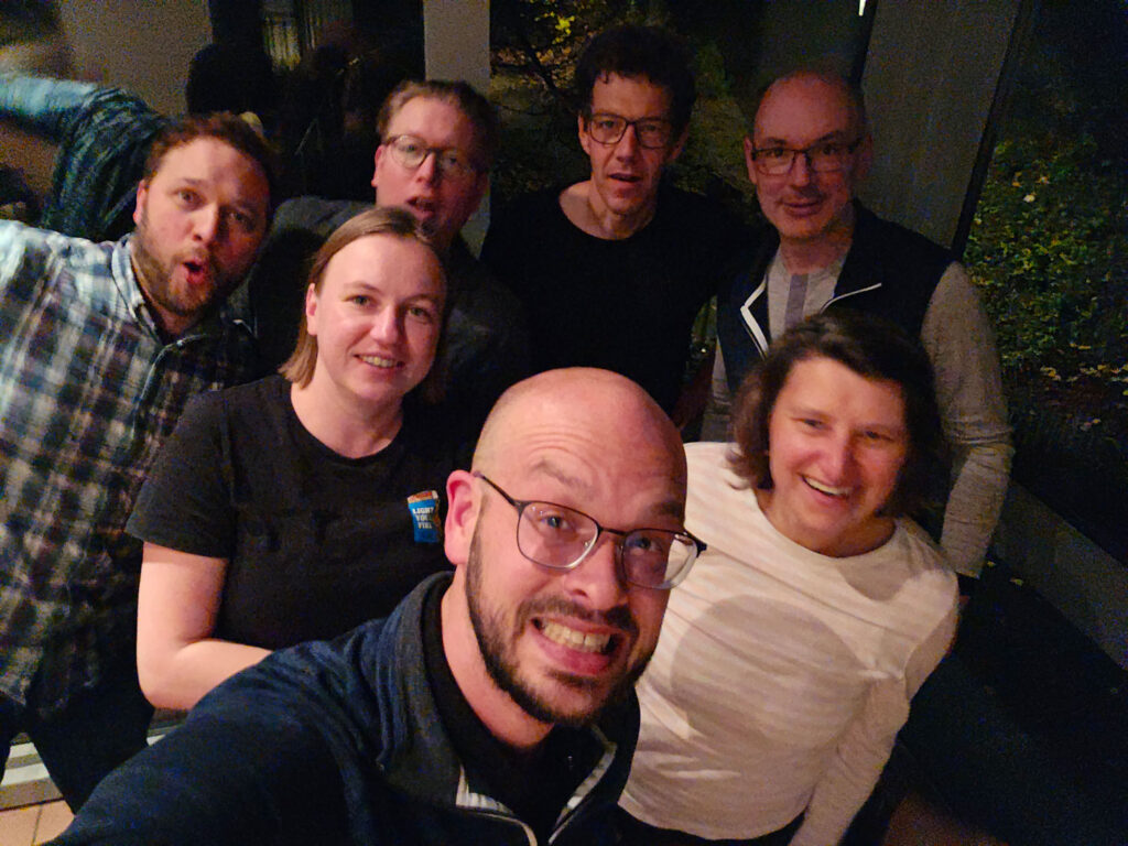 Selfie von sechs Personen am Abend in einem Raum