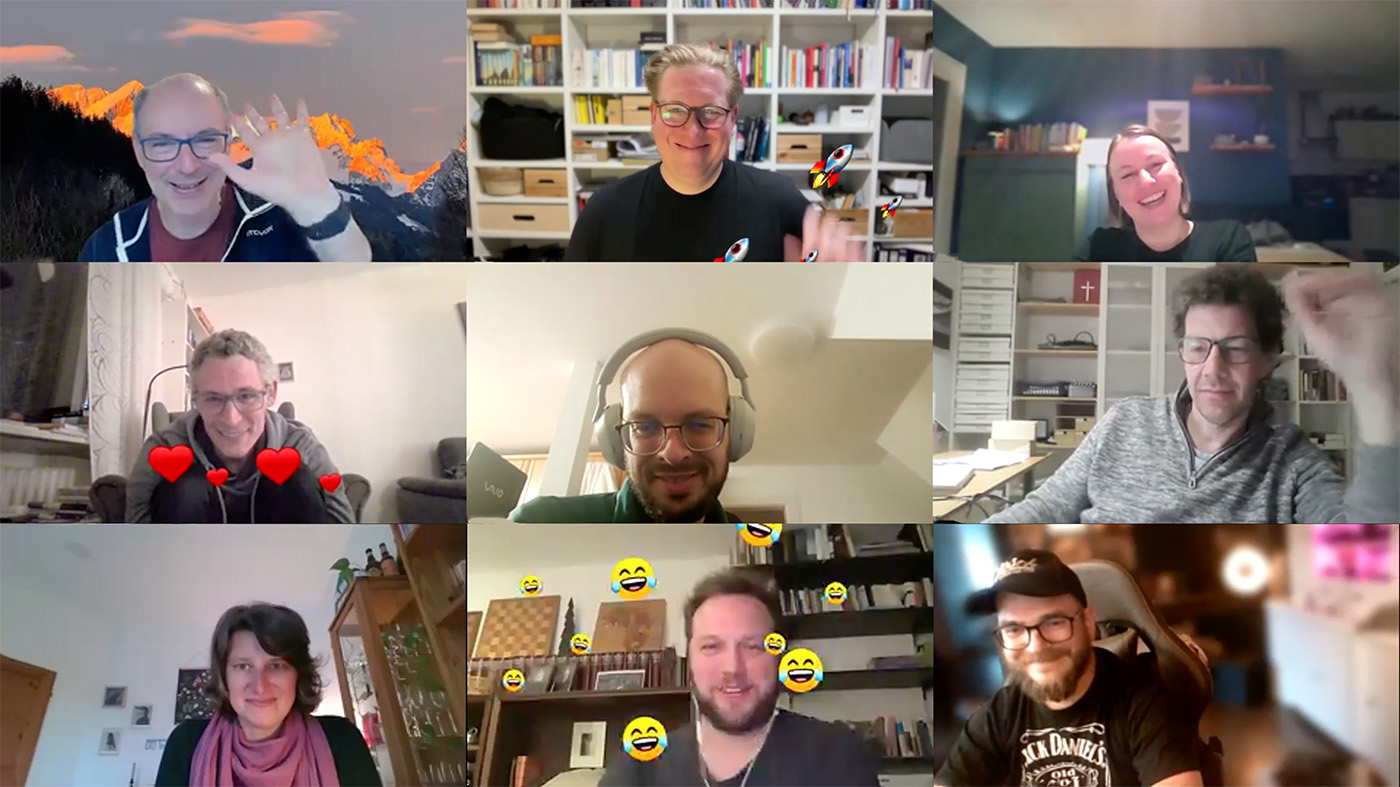 Screenshot von einem Online-Meeting, auf dem neun Personen in die Kamera lächeln und winken